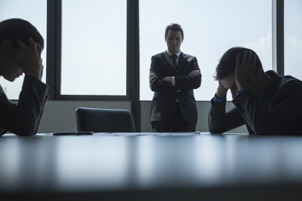 Three frustrated and overworked business people in the board room