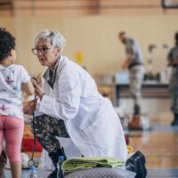 profesional de mediana edad atiende a una niña pequeña