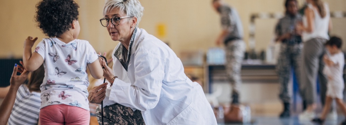 profesional de mediana edad atiende a una niña pequeña
